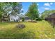 Private backyard with a stone fire pit, mature trees, patio furniture, and views of the lanai at 13469 Pia Ct, Spring Hill, FL 34609