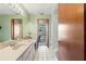 Bathroom with long vanity, tiled floors, and shower with view of pool at 13469 Pia Ct, Spring Hill, FL 34609