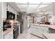 Well-lit kitchen featuring modern appliances, white cabinets, and a view of the outdoor dining area at 13469 Pia Ct, Spring Hill, FL 34609