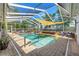 Resort-style screened-in pool with comfortable seating and a tranquil waterfall feature at 13469 Pia Ct, Spring Hill, FL 34609