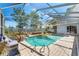 Stunning screened-in pool offering an oasis with outdoor seating and a waterfall feature at 13469 Pia Ct, Spring Hill, FL 34609