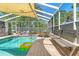 Enjoy the screened-in pool with a waterfall feature and plenty of seating for relaxing outdoors at 13469 Pia Ct, Spring Hill, FL 34609