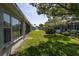 Well-maintained backyard featuring lush green grass and mature trees, offering privacy and outdoor enjoyment at 14105 Agua Clara Dr, Hudson, FL 34667