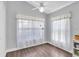 Bright bedroom with large windows, ceiling fan, and neutral decor at 14105 Agua Clara Dr, Hudson, FL 34667