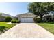 Charming single-story home with a well-manicured lawn, a brick driveway, and a two-car garage at 14105 Agua Clara Dr, Hudson, FL 34667