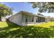 Exterior home view showing a pristine stucco wall and screened-in patio, seamlessly connecting indoor and outdoor spaces at 14105 Agua Clara Dr, Hudson, FL 34667