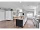 Open kitchen with granite counters, island seating, and wood flooring at 14105 Agua Clara Dr, Hudson, FL 34667