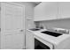 Modern laundry room with updated washer and dryer and ample storage cabinets at 14105 Agua Clara Dr, Hudson, FL 34667