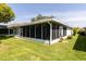 Exterior view of a screened-in patio, offering an outdoor living space with shade and protection from insects at 14105 Agua Clara Dr, Hudson, FL 34667
