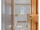 Clean bathroom featuring white tile, shower, and an arched window at 15535 Allmand Dr, Hudson, FL 34667