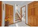 Bright hallway featuring wood door frames, tile floors, and staircase at 15535 Allmand Dr, Hudson, FL 34667