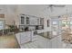 This is an open concept kitchen with an island and granite counters, and white cabinets at 15535 Allmand Dr, Hudson, FL 34667