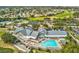 Aerial view of the clubhouse, tennis courts, golf course, and outdoor swimming pool at 18441 Whitacre Cir, Hudson, FL 34667