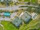 Overhead of community tennis and bocce ball courts near parking, streets and green spaces at 18441 Whitacre Cir, Hudson, FL 34667