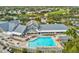 View of community pool, hot tub and clubhouse amenities surrounded by lounge chairs at 18441 Whitacre Cir, Hudson, FL 34667