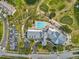 Aerial shot of community pool with clubhouse, pond, playground, golf greens, and parking at 18441 Whitacre Cir, Hudson, FL 34667
