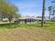 Lush backyard featuring a screened lanai, beautiful lawn, and mature trees at 18441 Whitacre Cir, Hudson, FL 34667