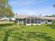 Well-maintained backyard featuring a screened lanai and a lush green lawn at 18441 Whitacre Cir, Hudson, FL 34667