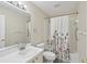 Cozy bathroom features a shower with a decorative curtain, toilet and sink at 18441 Whitacre Cir, Hudson, FL 34667