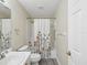 Cozy bathroom features a shower with a decorative curtain, toilet and sink at 18441 Whitacre Cir, Hudson, FL 34667