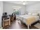 Bright bedroom features a ceiling fan, desk with computer, and a charming quilt-covered bed at 18441 Whitacre Cir, Hudson, FL 34667