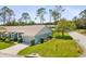 Well-maintained home with lush lawn, mature trees, and a two-car garage at 18441 Whitacre Cir, Hudson, FL 34667
