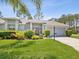 Attractive single-story home with manicured lawn, mature landscaping, and two-car garage at 18441 Whitacre Cir, Hudson, FL 34667