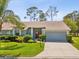 Charming single-story home with well-manicured lawn, mature landscaping, and two-car garage at 18441 Whitacre Cir, Hudson, FL 34667