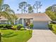 Charming single-story home features a well-maintained lawn, lush landscaping, and a two-car garage at 18441 Whitacre Cir, Hudson, FL 34667