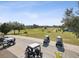 Scenic golf course view with golf carts parked nearby, perfect for golf enthusiasts and outdoor recreation at 18441 Whitacre Cir, Hudson, FL 34667
