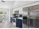 This kitchen features stainless steel appliances, white countertops, and blue lower cabinets at 18441 Whitacre Cir, Hudson, FL 34667