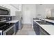 Modern kitchen boasts stainless steel appliances, white countertops, and stylish blue cabinets at 18441 Whitacre Cir, Hudson, FL 34667