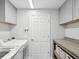 Well-organized laundry room with washer, dryer, shelving, and storage baskets at 18441 Whitacre Cir, Hudson, FL 34667