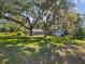 Secluded backyard oasis featuring mature trees, a pool, and the house at 196 Lark Ave, Brooksville, FL 34601