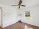 This bright bedroom offers wood floors, a ceiling fan, trim and natural light through the window at 196 Lark Ave, Brooksville, FL 34601