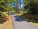 Long paved driveway leading to a wooded property, with brick columns and wooden fence at 196 Lark Ave, Brooksville, FL 34601