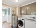 Functional laundry room with modern washer and dryer, water heater, cabinets and a glimpse into the next room at 196 Lark Ave, Brooksville, FL 34601