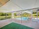 Screened in pool with clear blue water, ladder entry, and surrounded by mature trees and landscaping at 196 Lark Ave, Brooksville, FL 34601