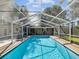Beautiful screened-in pool featuring sparkling water and tile trim at 196 Lark Ave, Brooksville, FL 34601