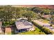 An aerial view showcases the home's screened in patio and fenced yard, nestled among lush trees in a residential neighborhood at 2116 Karan Way, Clearwater, FL 33763