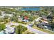 This aerial shows the home and surrounding neighborhood near a beautiful blue lake surrounded by lush trees and a community pool at 2116 Karan Way, Clearwater, FL 33763