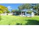 Manicured backyard featuring a screened porch, patio, lush green grass and mature trees for shade and privacy at 2116 Karan Way, Clearwater, FL 33763