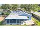 Rear exterior view features a screened porch, mature landscaping, and a classic roofline at 2116 Karan Way, Clearwater, FL 33763