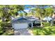 Charming home featuring a well-manicured front yard, mature trees, and a welcoming exterior at 2116 Karan Way, Clearwater, FL 33763