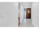 A hallway view showcases a solid wood entry door with decorative glass and coat closet storage solutions for guests at 2116 Karan Way, Clearwater, FL 33763