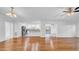 Bright, open-concept living space with wood floors flowing into a modern white kitchen and dining area at 2116 Karan Way, Clearwater, FL 33763