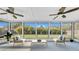 Relaxing screened-in patio with ceiling fans and views of the lush backyard at 2116 Karan Way, Clearwater, FL 33763