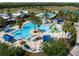 Aerial view of the community pool area with tropical landscaping, a kiddie pool, and ample seating at 21857 Adriatic Ln, Land O Lakes, FL 34637