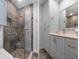 This remodeled bathroom has a walk-in shower with beautiful stonework and a sleek vanity at 2235 Lytham Ct, Spring Hill, FL 34606
