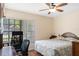 This comfortable bedroom offers a nice backyard view, desk, and ceiling fan at 2235 Lytham Ct, Spring Hill, FL 34606